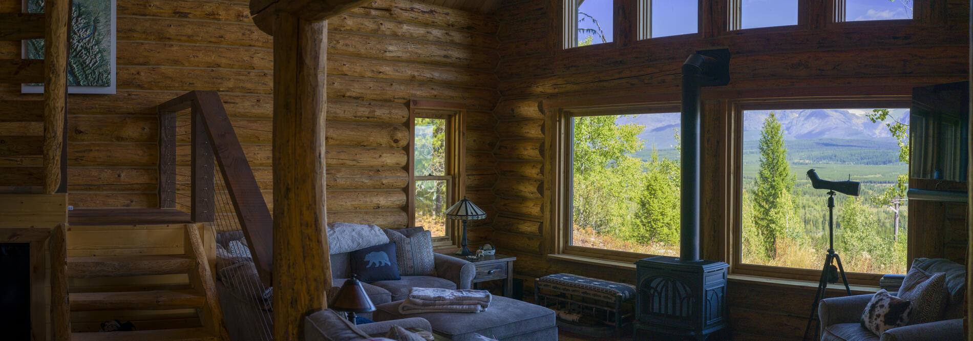 Living room with log walls and windows framing the mountains